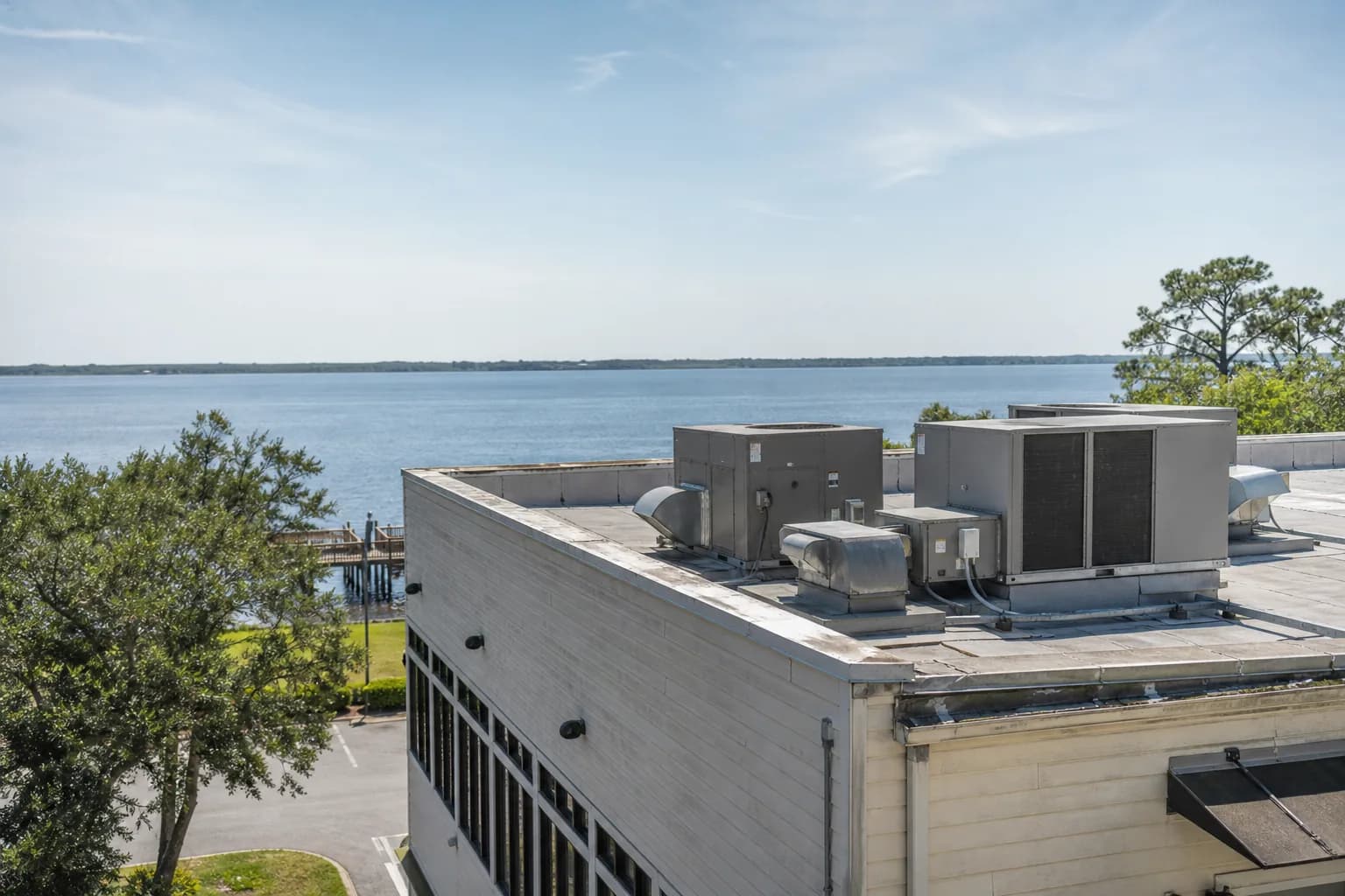 Air Solutions technician servicing rooftop commercial HVAC package units at a Foley, Alabama home, illustrating "Commerci HVAC for Baldwin County Businesses"