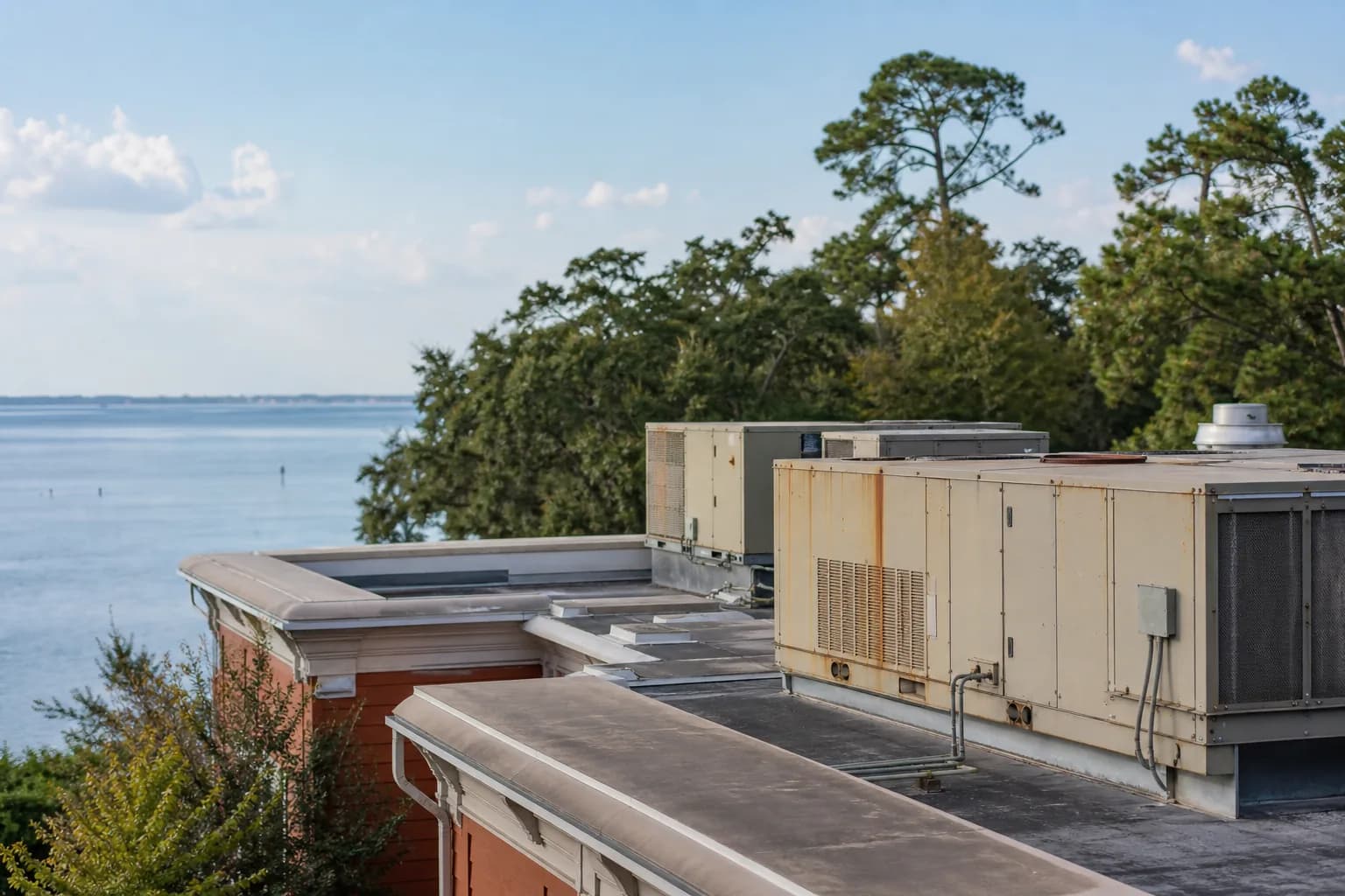 Air Solutions technician servicing rooftop commercial HVAC package units at a Daphne, Alabama home, illustrating "Commerci HVAC Maintenance Contract Pricing"