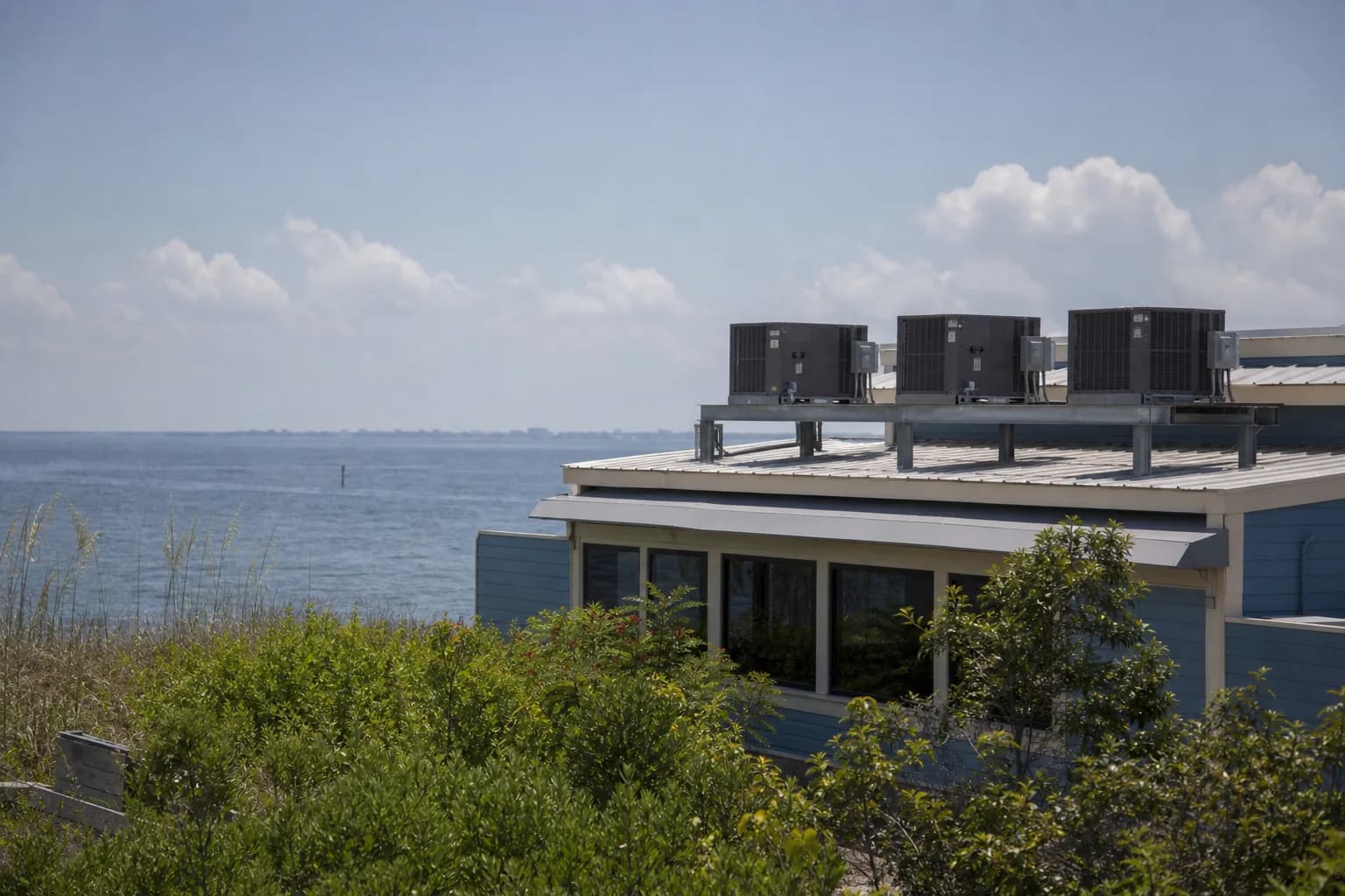 Air Solutions technician servicing rooftop commercial HVAC package units at a Fort Morgan, Alabama home, illustrating "Vacation Rent AC Failures Between Guests: The Turnover Playbook"