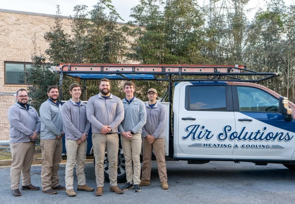 The Air Solutions Heating & Cooling team in front of their service trucks in Daphne, Alabama.