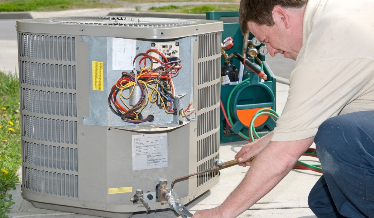 Technician repairing air conditioning unit.
